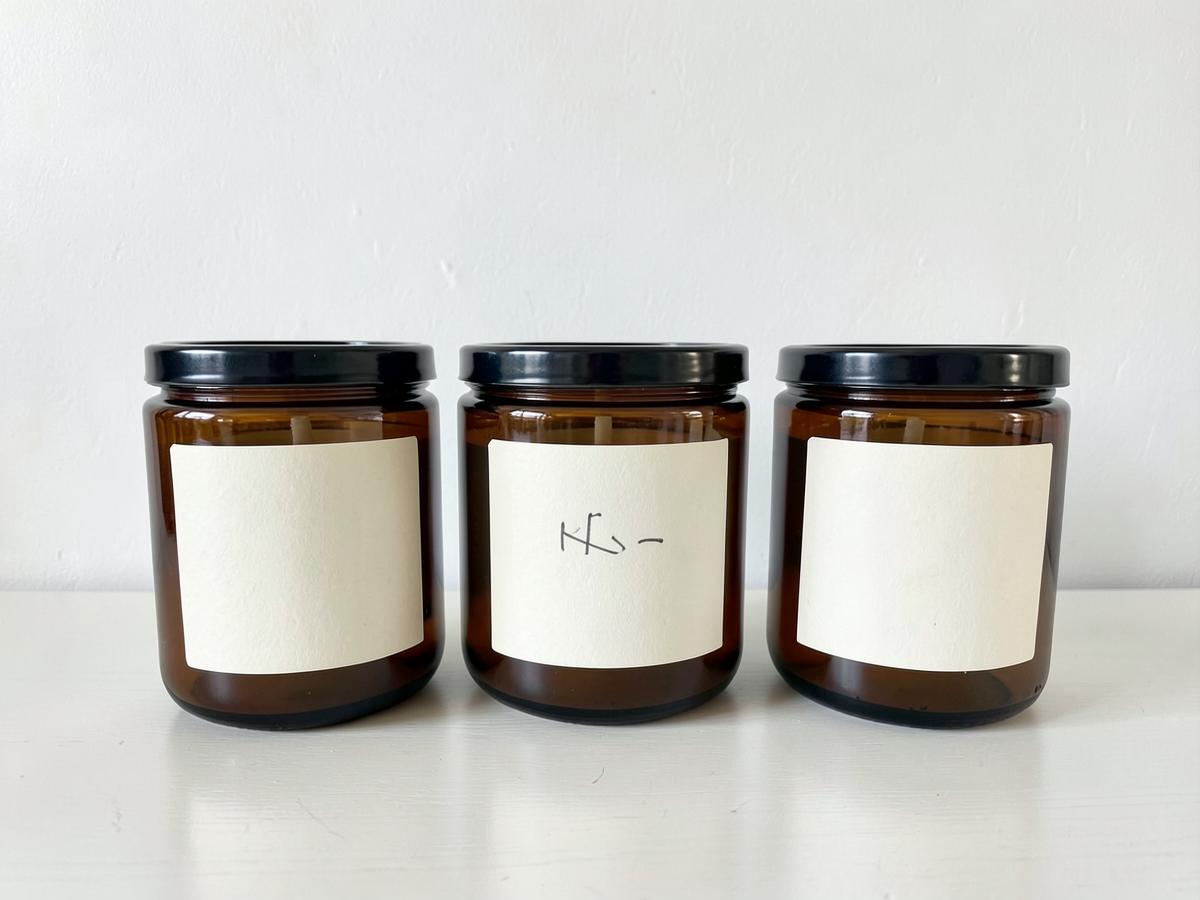 Source photo: three amber candle jars photographed against a plain wall